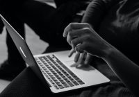 Black and white photo: Student works with laptop in lap