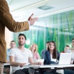 man lecturing in classroom environment